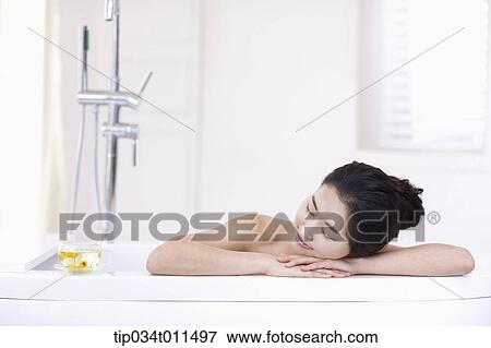 Stock Photo - a woman in leaning on a Jacuzzi. Fotosearch