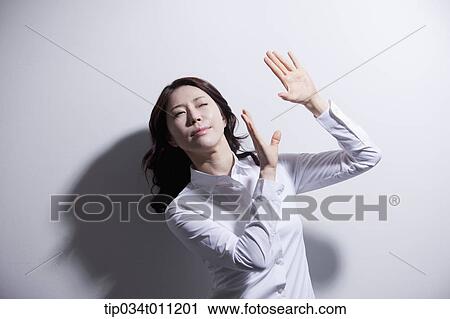 Stock Image - a woman in white shirt avoiding sun light. Fotosearch