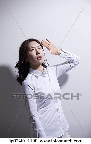 a woman in white shirt avoiding sun light View Large Photo Image Stock Photo - a woman in white shirt avoiding sun light. Fotosearch