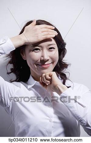 Stock Image - a woman in white shirt enjoying the sun light. Fotosearch
