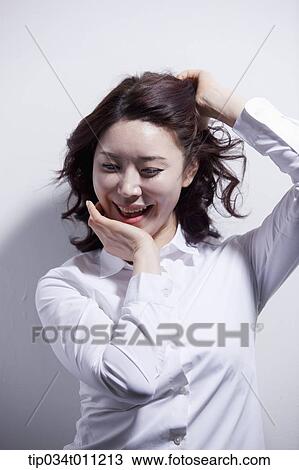 Stock Image - a woman in white shirt enjoying the sun light. Fotosearch