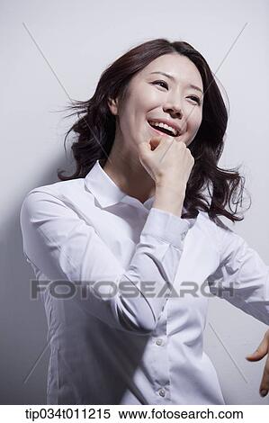 Stock Photography - a woman in white shirt enjoying the sun light. Fotosearch