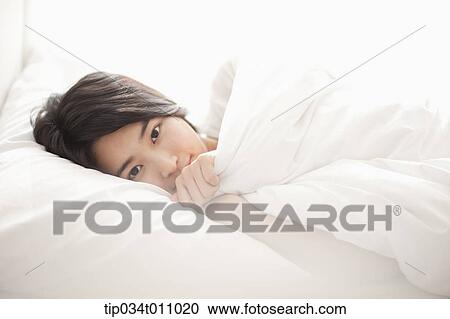 a woman on the be hugging a pillow View Large Photo Image Stock Image - a woman on the be hugging a pillow. Fotosearch