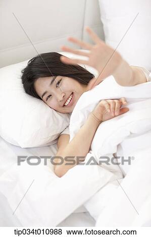Stock Photo - a woman on the bed smiling. Fotosearch