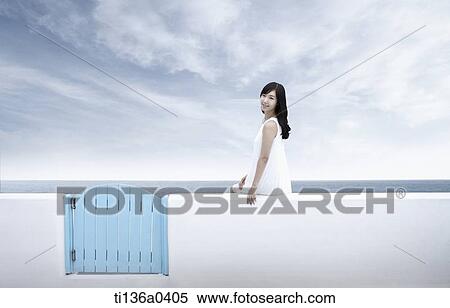 Stock Photography - a woman sitting on a fence. Fotosearch