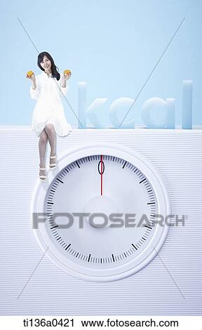 a woman sitting on a weight scale View Large Photo Image Stock Image - a woman sitting on a weight scale. Fotosearch