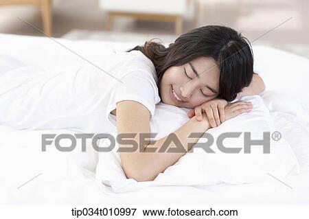 a woman sleeping on the bed View Large Photo Image Stock Photo - a woman sleeping on the bed. Fotosearch