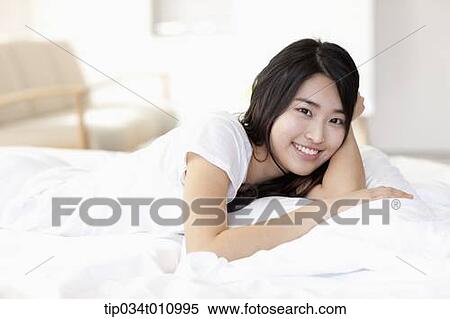 a woman smiling on the bed View Large Photo Image Stock Photography - a woman smiling on the bed. Fotosearch