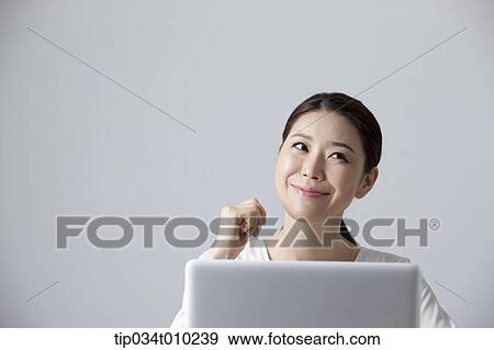 a woman smiling while using a laptop View Large Photo Image Stock Photo - a woman smiling while using a laptop. Fotosearch