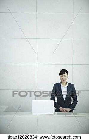 Picture - a woman standing in the reception. Fotosearch