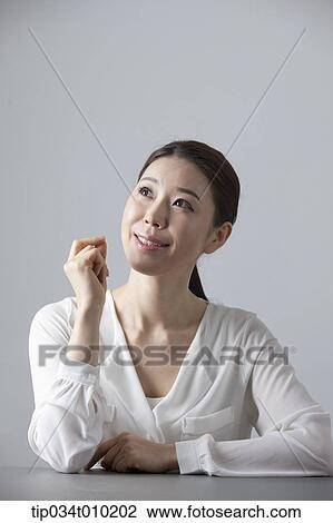 a woman thinking while sitting at a desk View Large Photo Image Stock Image - a woman thinking while sitting at a desk. Fotosearch