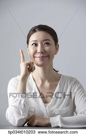 a woman thinking while sitting at a desk View Large Photo Image Stock Image - a woman thinking while sitting at a desk. Fotosearch