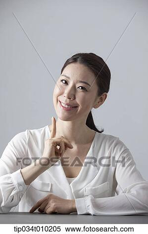 a woman thinking while sitting at a desk View Large Photo Image Stock Photography - a woman thinking while sitting at a desk. Fotosearch