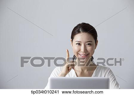 Stock Image - a woman thinking while using a laptop. Fotosearch