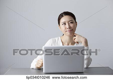 a woman thinking while using a laptop View Large Photo Image Stock Photograph - a woman thinking while using a laptop. Fotosearch