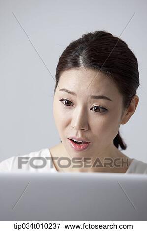 Stock Photo - a woman using a laptop. Fotosearch
