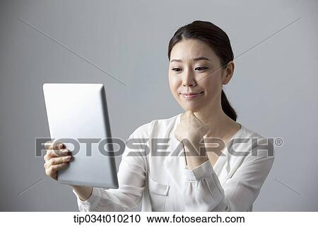 Stock Image - a woman using a tablet PC . Fotosearch
