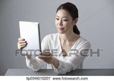 Stock Photo - a woman using a tablet PC . Fotosearch