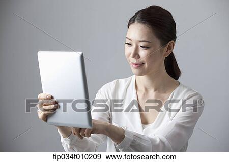 Stock Photo - a woman using a tablet PC . Fotosearch