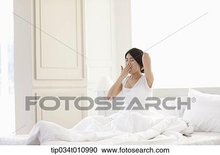 Stock Image - a woman waking up from sleep. Fotosearch