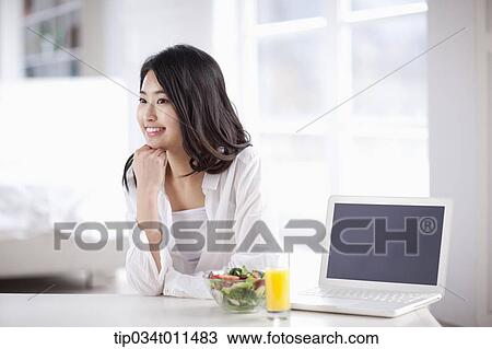 a woman with a laptop with juice and salad View Large Photo Image Stock Image - a woman with a laptop with juice and salad. Fotosearch
