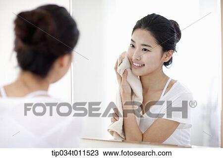 Stock Image - a woman with a towel on her face. Fotosearch