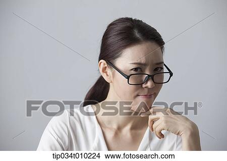 Picture - a woman with glasses thinking. Fotosearch
