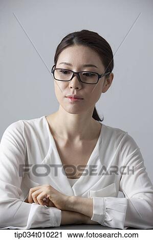 a woman with glasses thinking View Large Photo Image Stock Image - a woman with glasses thinking. Fotosearch