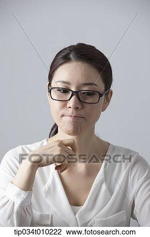 Stock Image - a woman with glasses thinking. Fotosearch