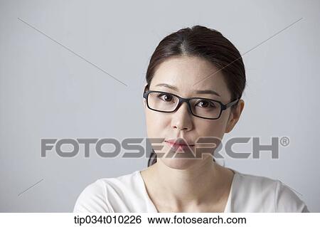 a woman with glasses thinking View Large Photo Image Stock Photograph - a woman with glasses thinking. Fotosearch
