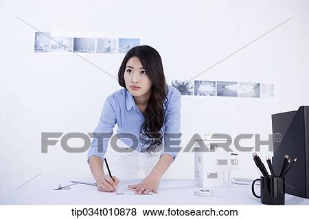 an interior designer at her desk with a model house View Large Photo Image Stock Photo - an interior designer at her desk with a model house. Fotosearch
