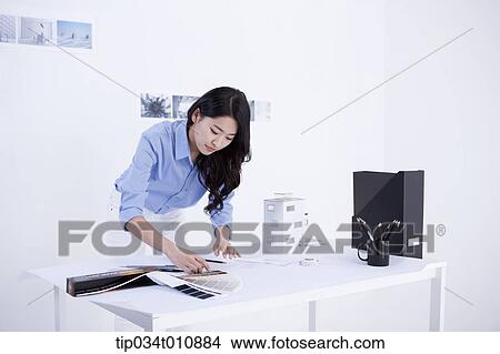 an interior designer looking at colour scales View Large Photo Image Picture - an interior designer looking at colour scales. Fotosearch