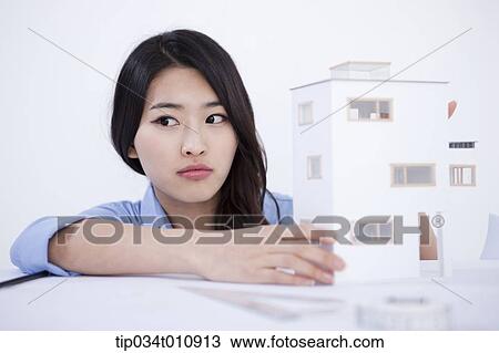 Stock Image - an interior designer with a model house. Fotosearch
