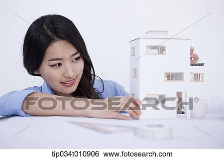 Stock Photograph - an interior designer with a model house. Fotosearch
