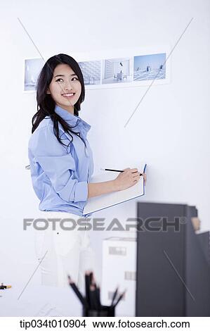 Picture - an interior designer with a sketch book. Fotosearch