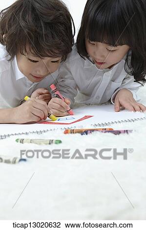 Stock Image - brother and sister drawing on a paper. Fotosearch