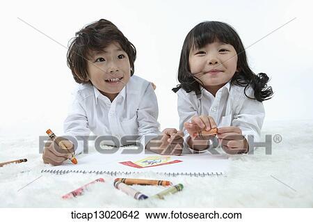 Stock Image - brother and sister drawing on a paper. Fotosearch