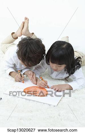 Stock Photo - brother and sister drawing on a paper. Fotosearch