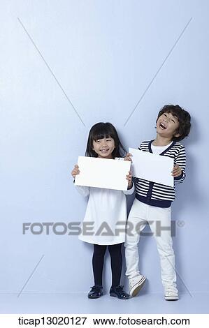 Stock Photo - brother and sister holding blank papers. Fotosearch