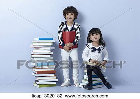 Stock Image - brother and sister reading books. Fotosearch