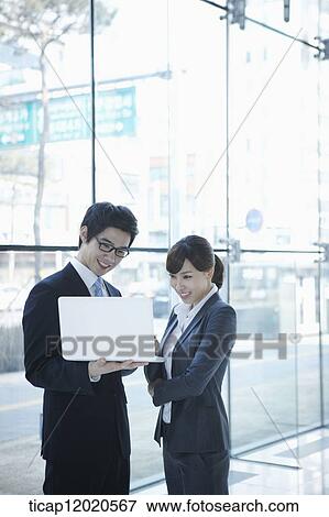 Stock Photo - business people looking at a laptop. Fotosearch