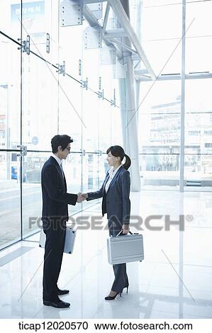 Stock Image - business people shaking hands. Fotosearch