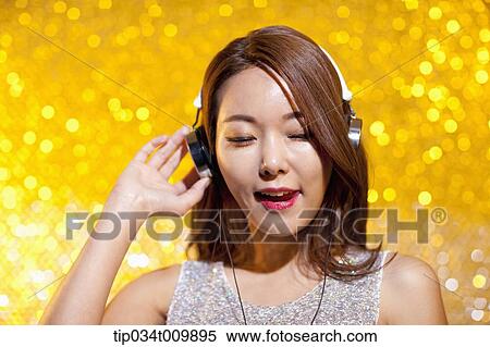close up of a woman in fancy dress listening to music with headphone View Large Photo Image Stock Photography - close up of a woman in fancy dress listening to music with headphone. Fotosearch