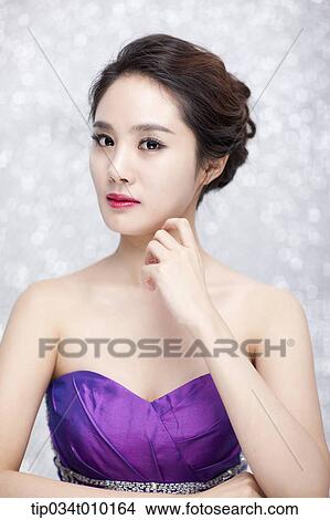 Picture - close up of a woman in purple dress posing gracefully . Fotosearch