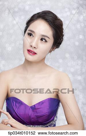 Stock Image - close up of a woman in purple dress posing gracefully . Fotosearch