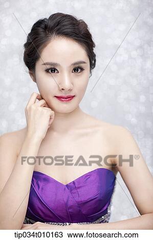 Stock Image - close up of a woman in purple dress posing gracefully . Fotosearch