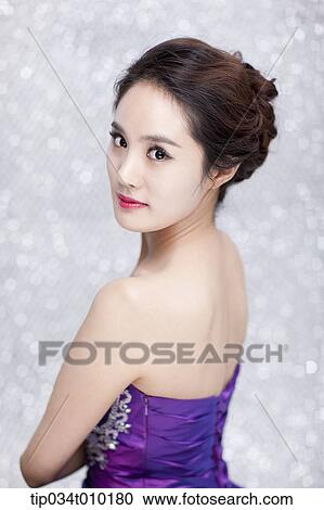 Stock Image - close up of a woman in purple dress posing gracefully . Fotosearch