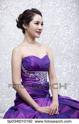Stock Image - close up of a woman in purple dress posing gracefully . Fotosearch