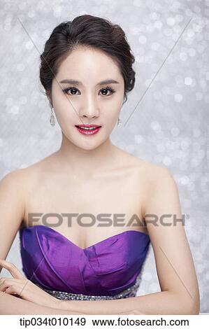 Stock Photo - close up of a woman in purple dress posing gracefully . Fotosearch