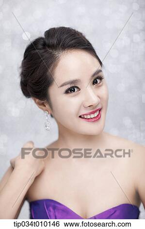 Stock Photograph - close up of a woman in purple dress posing gracefully . Fotosearch
